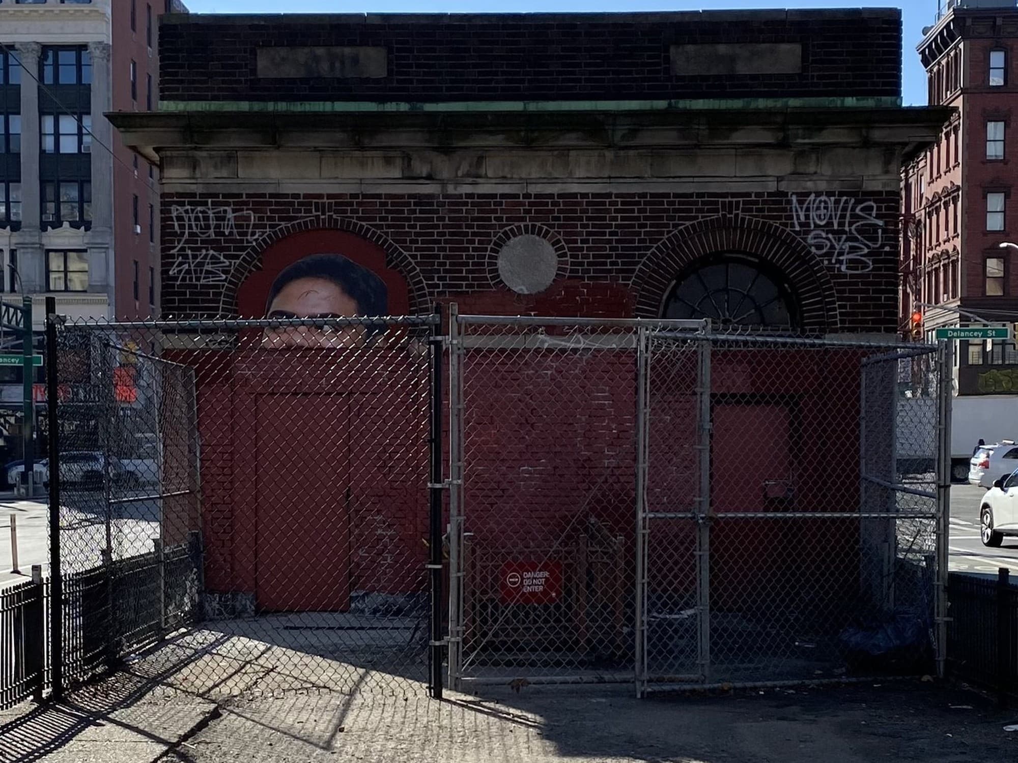 The building's entrance today, seen through the chain-link fence